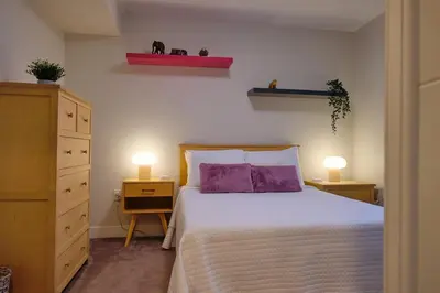 a bedroom with a bed with purple pillows and two lamps at Denver Lower Highlands Modern Home in Denver