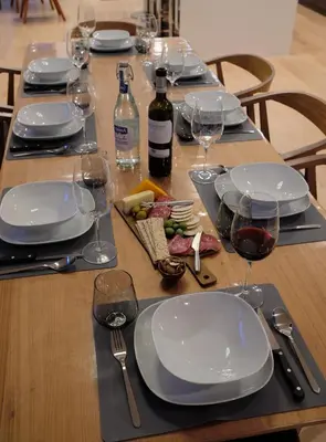 a wooden table with plates and wine glasses on it at Denver Lower Highlands Modern Home in Denver
