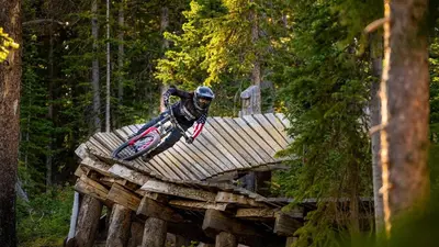 a man riding a dirt bike over a wooden bridge at Cozy Downtown Condo with Jacuzzi 5 Min to Resort in Winter Park