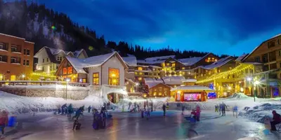 a group of people skating on the ice at night at Cozy Downtown Condo with Jacuzzi 5 Min to Resort in Winter Park