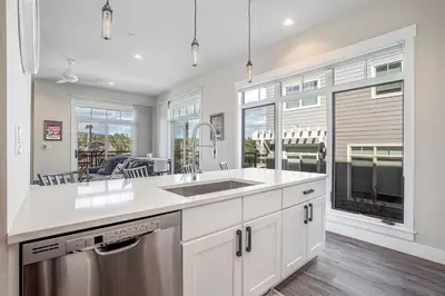a kitchen with a sink and a large window at Cozy Downtown Condo with Jacuzzi 5 Min to Resort in Winter Park