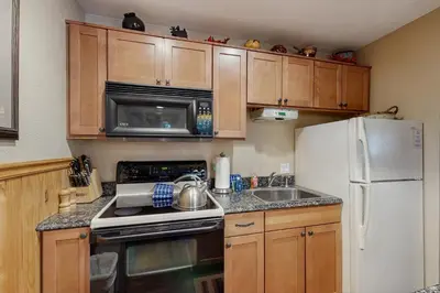 a kitchen with wooden cabinets and a white refrigerator at Hi Country Haus 11-12 in Winter Park