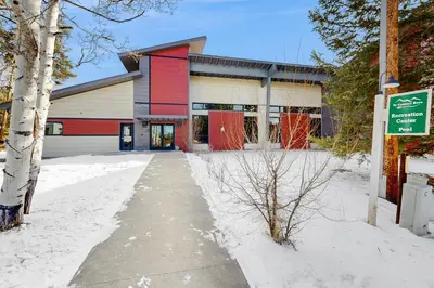 a building with a red and white facade in the snow at Hi Country Haus 11-12 in Winter Park