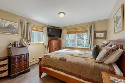 a bedroom with a bed with a dresser and a window at Hi Country Haus 11-12 in Winter Park