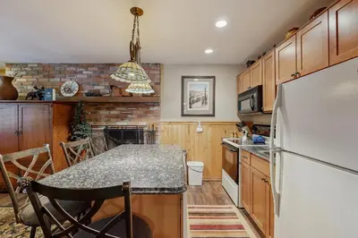a kitchen with a white refrigerator and a table at Hi Country Haus 11-12 in Winter Park