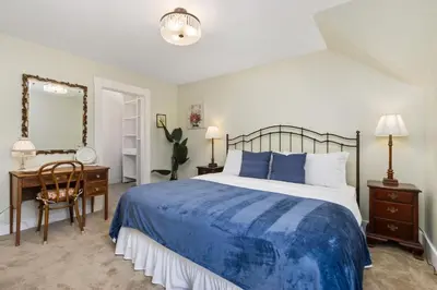 a bedroom with a bed and a desk and a mirror at City Park Charm - Vintage Home with Modern Comforts in Fort Collins