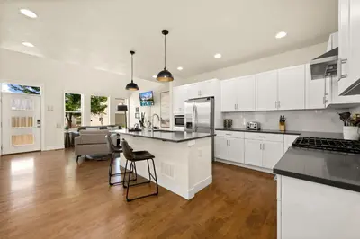 a kitchen with white cabinets and black counter tops at The Colorado House in Old Town Brewery District in Fort Collins