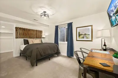 a bedroom with a bed and a table and a desk at The Colorado House in Old Town Brewery District in Fort Collins