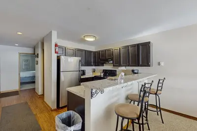 a kitchen with a counter and a refrigerator and chairs at Lakeview Peaks in Dillon