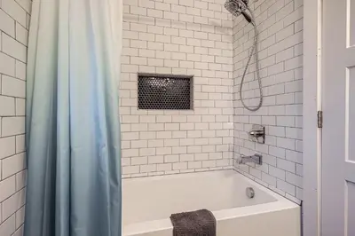 a white bathroom with a tub and a shower at Spacious Denver home in Denver