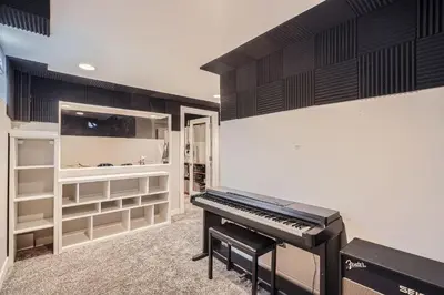 a black piano in a room with shelves at Spacious Denver home in Denver
