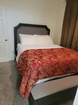 a bed with a red blanket on top of it at Ram comfort in DEN