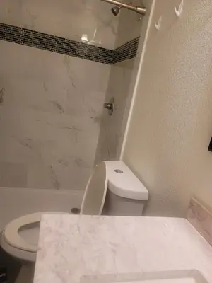 a bathroom with a toilet and a tub and a sink at Ram comfort in DEN
