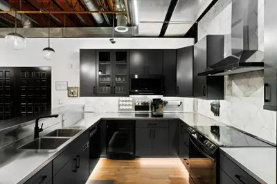 a kitchen with black and white cabinets and a sink at Suite No 1 in Denver
