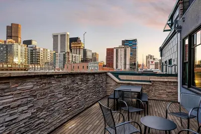 a balcony with chairs and tables and a city skyline at Suite No 1 in Denver