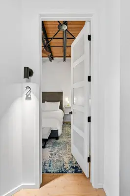 a white door leading to a bedroom with a bed at Suite No 1 in Denver