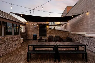 a patio with a table and chairs on a brick wall at Suite No 2 in Denver