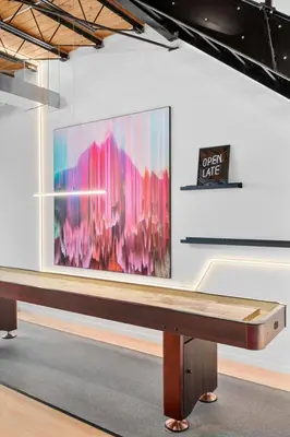 a large painting on a white wall with a bench at Suite No 2 in Denver