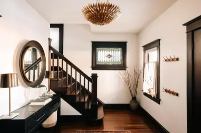 a hallway with a black staircase and a mirror at Exquisite Craftsman - RiNo&Cole - Backyard Garden in Denver
