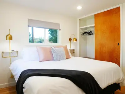 a bedroom with a large white bed with pink pillows at Entire House Kid Ready Yard in Arvada