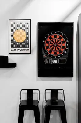 a dart board on a wall with two stools at Suite No 1 & No 2 in Denver