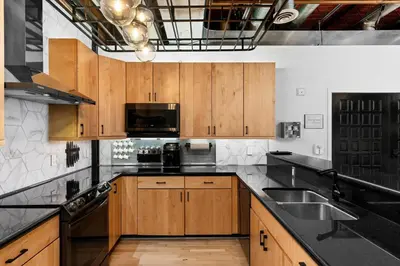 a kitchen with wooden cabinets and black counter tops at Suite No 1 & No 2 in Denver