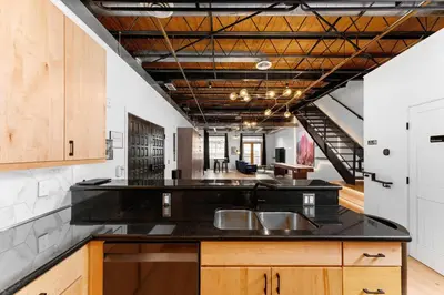 a kitchen with a black counter top and wooden cabinets at Suite No 1 & No 2 in Denver