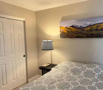 a bedroom with a bed and a lamp and a painting at Modern Haven Scenic Nature Views Near Chatfield Park in Littleton