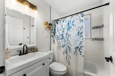 a bathroom with a sink toilet and a shower curtain at Modern Family Friendly Escape Central 5 Bedroom in Denver
