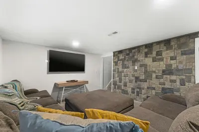 a living room with a couch and a flat screen tv at Modern Family Friendly Escape Central 5 Bedroom in Denver