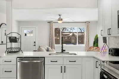 a kitchen with white cabinets and a stove top oven at Modern Family Friendly Escape Central 5 Bedroom in Denver