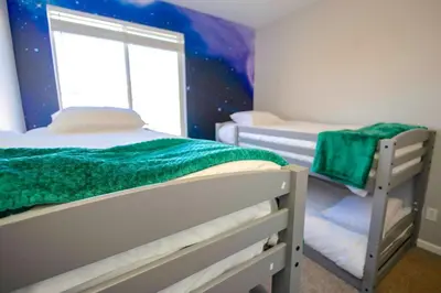 a bedroom with two bunk beds and a window at Spacious 4BD Near Denver w BBQ, Game Room & Office in Commerce City