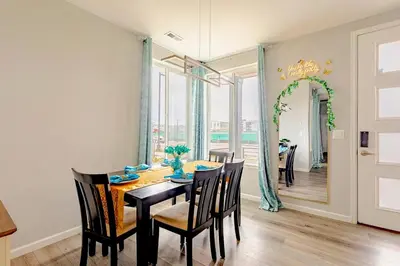 a dining room with a table and chairs and a mirror at Spacious 4BD Near Denver w BBQ, Game Room & Office in Commerce City