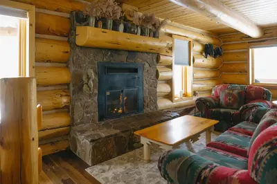 a living room with a fireplace in a log cabin at Silverthorne Cabin with Hot Tub and Forest Access in Silverthorne