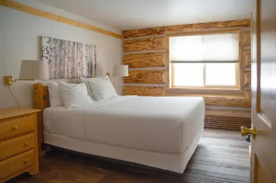 a bedroom with a white bed and a window at Silverthorne Cabin with Hot Tub and Forest Access in Silverthorne