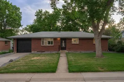 a brick house with a tree in the yard at Huge Hot Tub, Theater Room, Family Friendly Oasis in Arvada