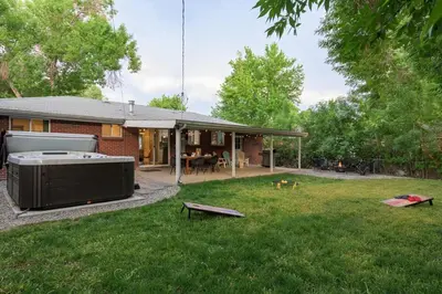 a backyard with a hot tub in the grass at Huge Hot Tub, Theater Room, Family Friendly Oasis in Arvada