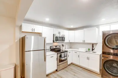 a kitchen with white cabinets and a stainless steel refrigerator at 8 Mi to Dtwn Denver Haven with Patio and Yard! in Denver