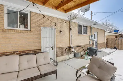a patio with a couch and a chair in front of a building at 8 Mi to Dtwn Denver Haven with Patio and Yard! in Denver