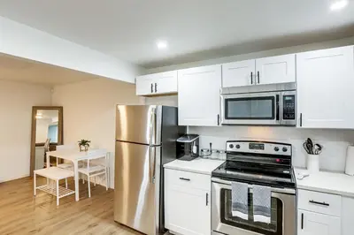 a kitchen with white cabinets and a stainless steel refrigerator at 8 Mi to Dtwn Denver Haven with Patio and Yard! in Denver