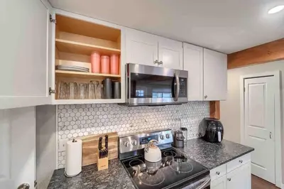 a kitchen with a stove and a microwave at 4BR Longmont Escape with Cold Plunge & Sauna - Pets OK! in Longmont