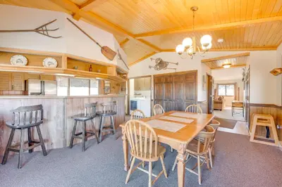 a kitchen and dining room with a wooden table and chairs at 3 Mi to Rocky Mtn National Park Estes Park Cabin! in Estes Park