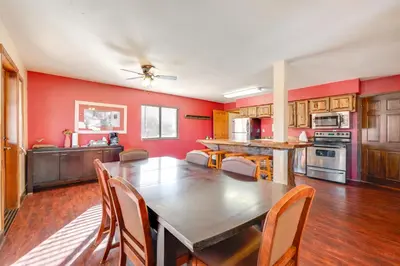 a kitchen with red walls and a wooden table and chairs at 3 Mi to Rocky Mtn National Park Estes Park Cabin! in Estes Park