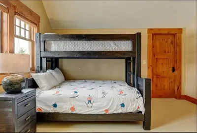 a bedroom with a bunk bed and a desk with a lamp at Luxe Winter Park Escape - 5BR with Hot Tub & Game Room in Winter Park