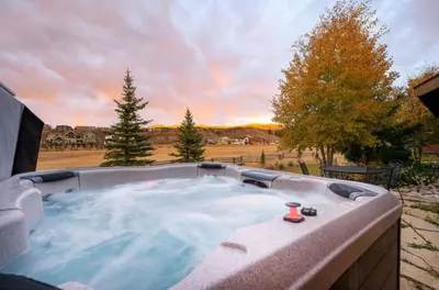 a hot tub with a view of a field at Luxe Winter Park Escape - 5BR with Hot Tub & Game Room in Winter Park