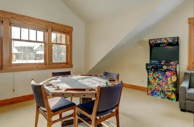a dining room with a table and a television at Luxe Winter Park Escape - 5BR with Hot Tub & Game Room in Winter Park