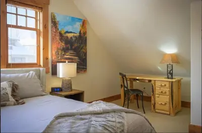 a bedroom with a bed and a desk and a window at Luxe Winter Park Escape - 5BR with Hot Tub & Game Room in Winter Park