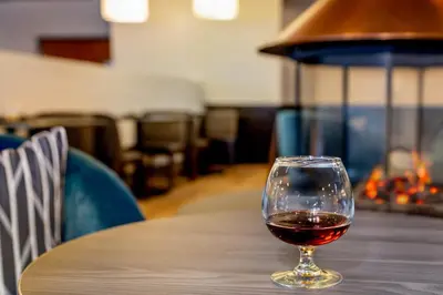 a glass of wine sitting on a table at Holiday Inn Frisco by IHG in Frisco