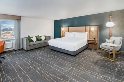 a hotel room with a bed and a chair at Holiday Inn Frisco by IHG in Frisco