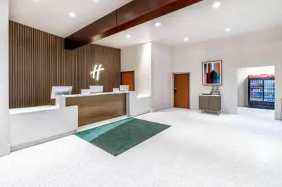 an office lobby with a reception desk and a green rug at Holiday Inn Frisco by IHG in Frisco